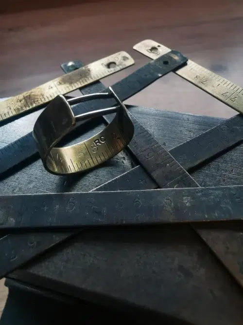 Détail d’une bague en laiton et argent façonnée à la main à partir d’une règle de couturier recyclée.