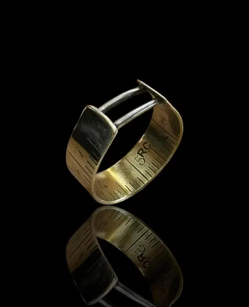Bague artisanale en laiton doré gravé, ornée de deux fils d’argent, créée à partir d’une règle de couturier recyclée.