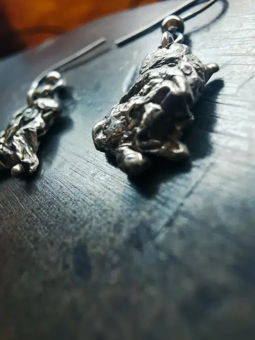 Détail de boucles d’oreilles en argent 925 au design organique et brut, créées par un artisan bijoutier dans le Gard.